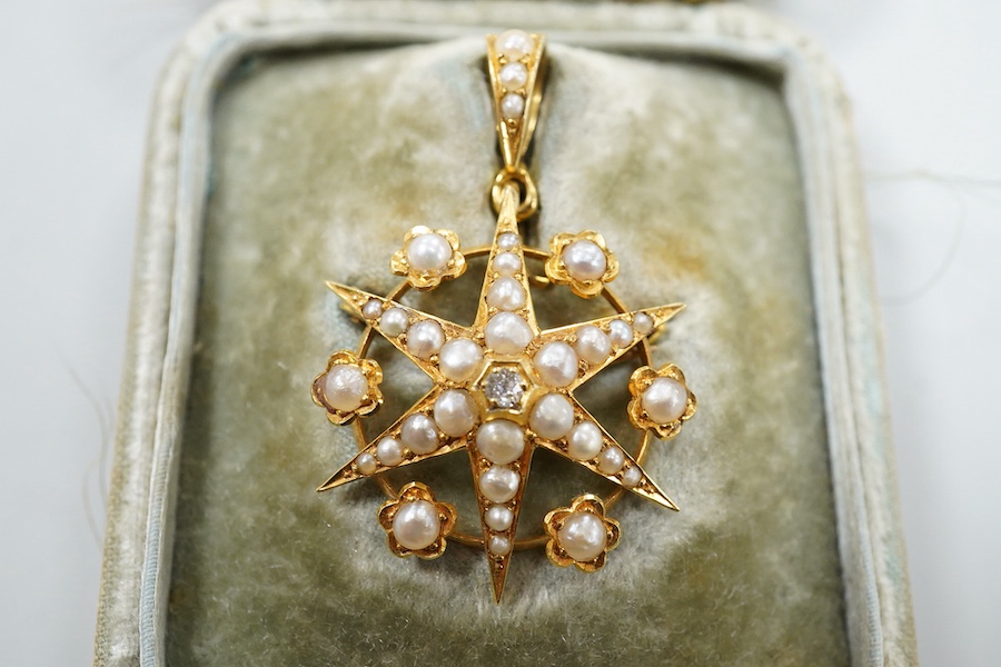 A Victorian yellow metal (stamped 18), diamond and graduated split pearl set star pendant brooch, makers mark SS, 39mm including the bale, gross weight 5.2 grams, with fitted box.